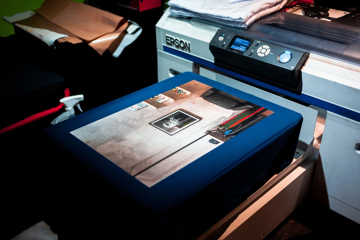 Epson commercial direct-to-garment (DTG) printer printing a custom apparel design