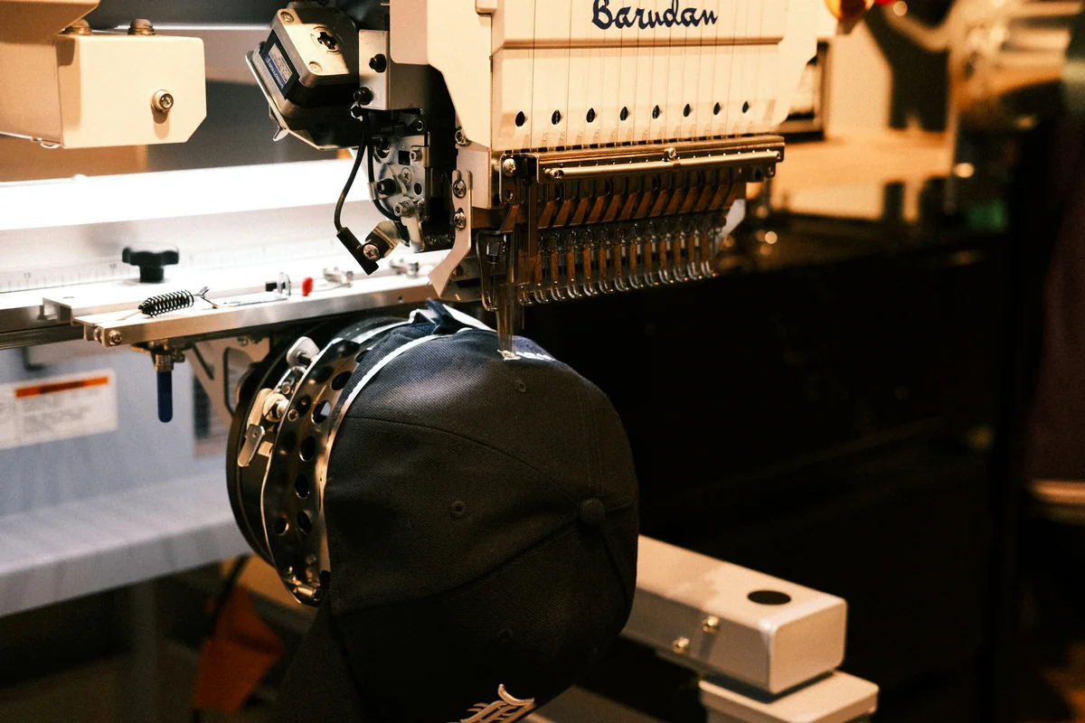 Commercial multi-needle embroidery machine — Barudan cap-frame detail